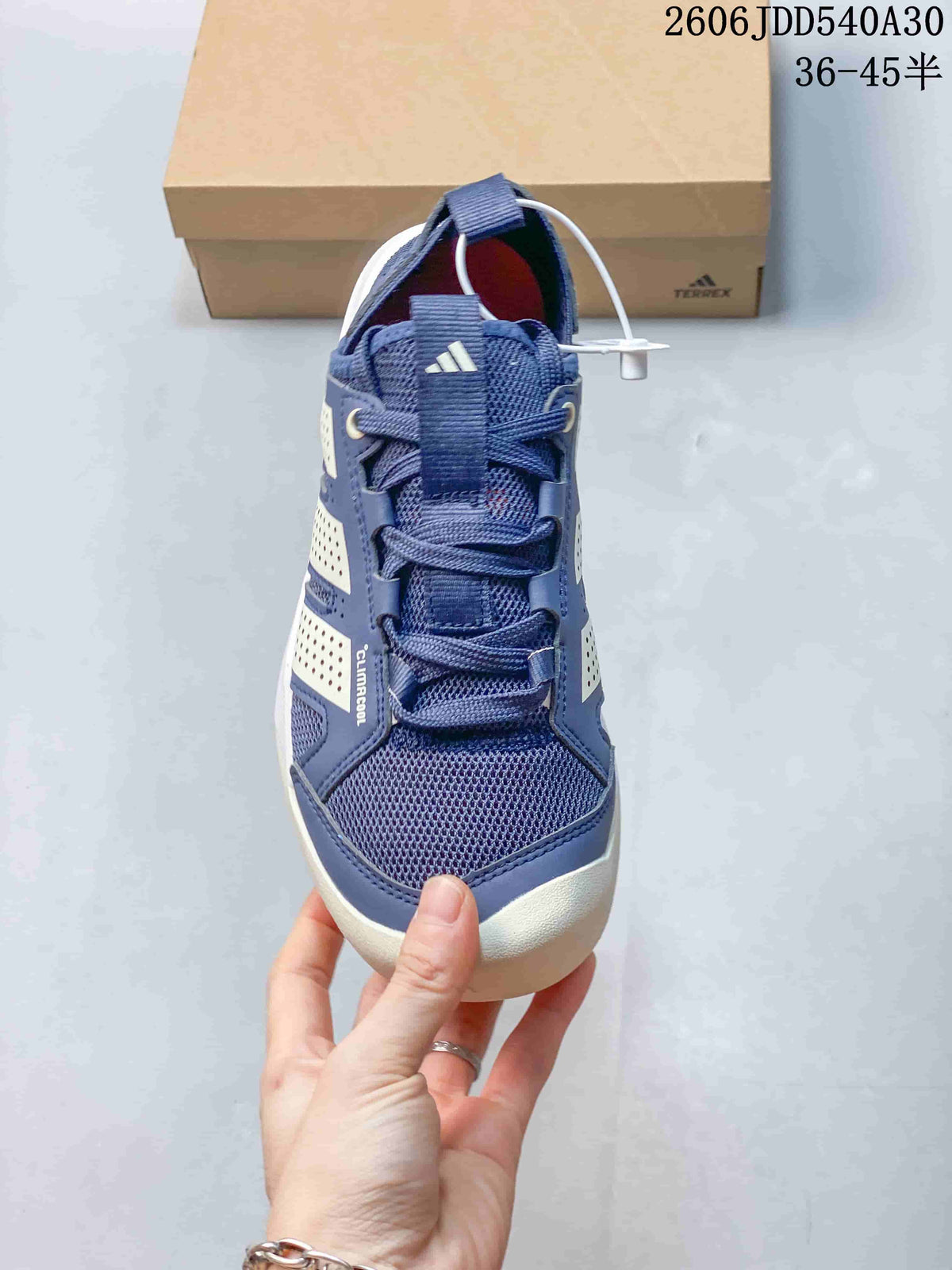 Front view of a blue Terrex sneaker showing the laces, tongue strap, and mesh-like toe area.