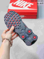 Outsole view showing the tread and red heel columns of a grey Nike Shox Ride 2 sneaker