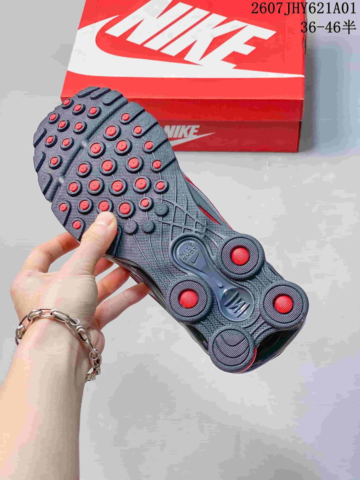 Outsole view showing the tread and red heel columns of a grey Nike Shox Ride 2 sneaker