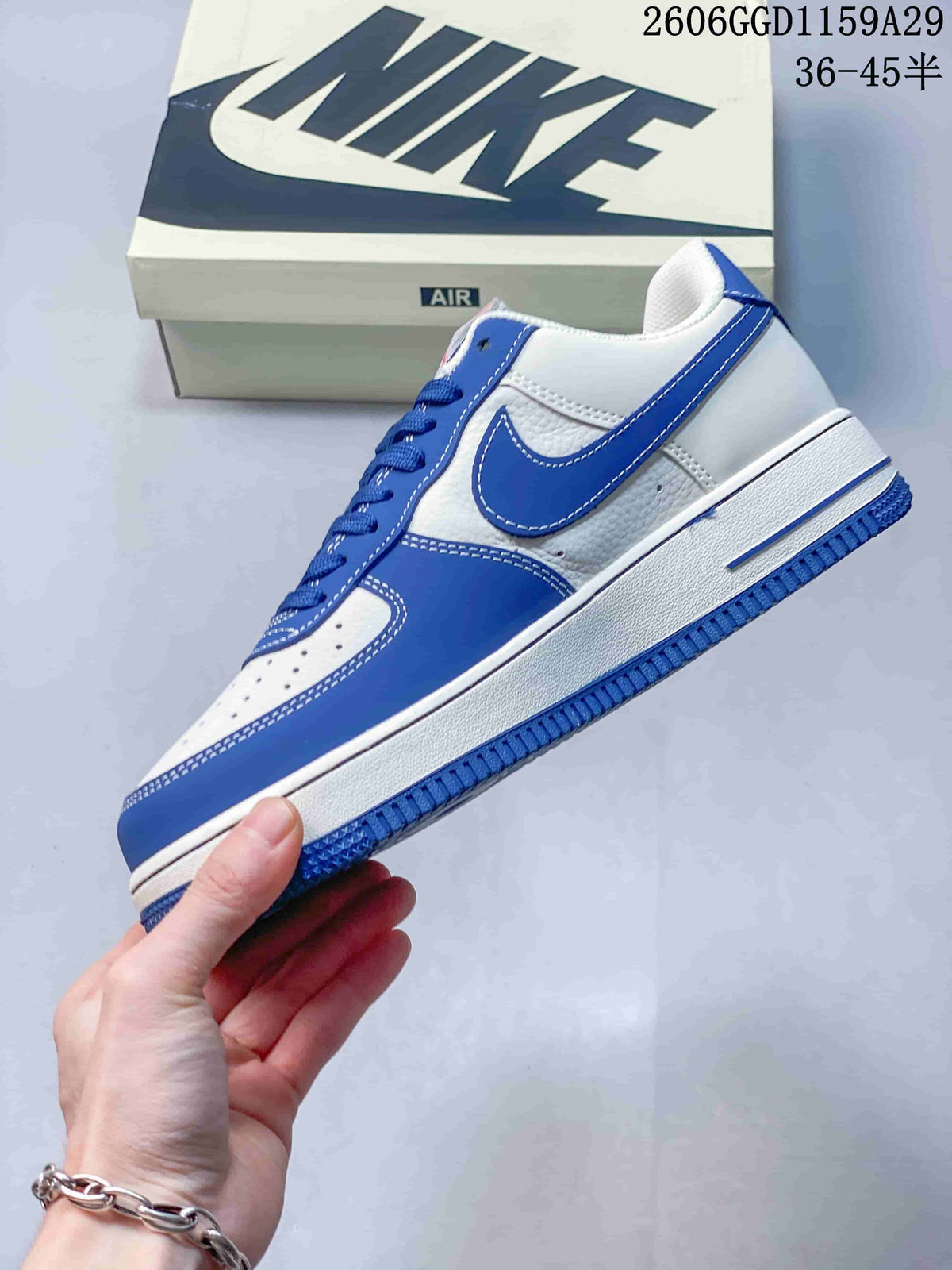 Side profile of the white and blue low-top sneaker with contrast stitching and a blue outsole.