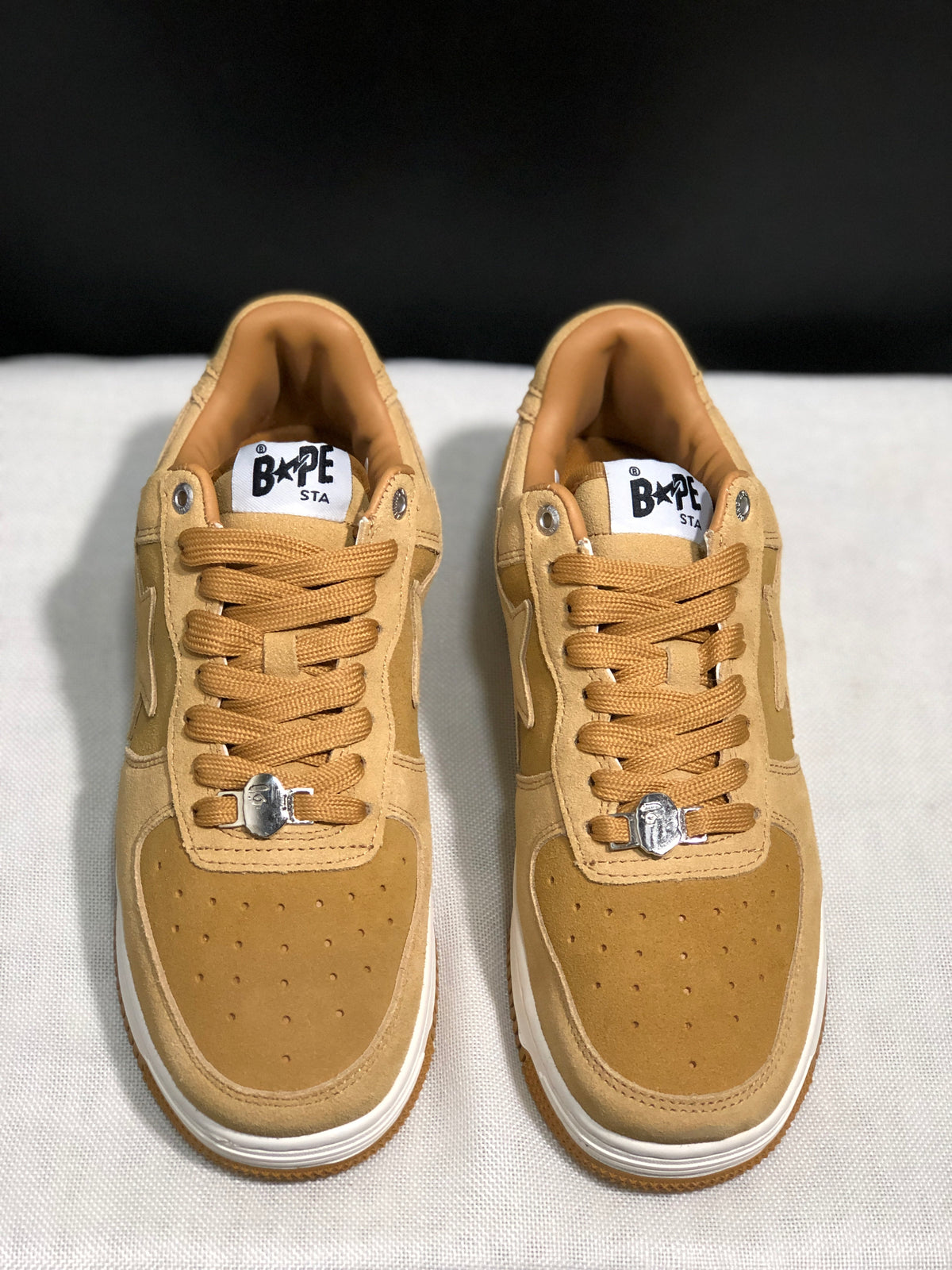 Front view of the pair showing the wheat uppers, perforated toe boxes and white midsoles.