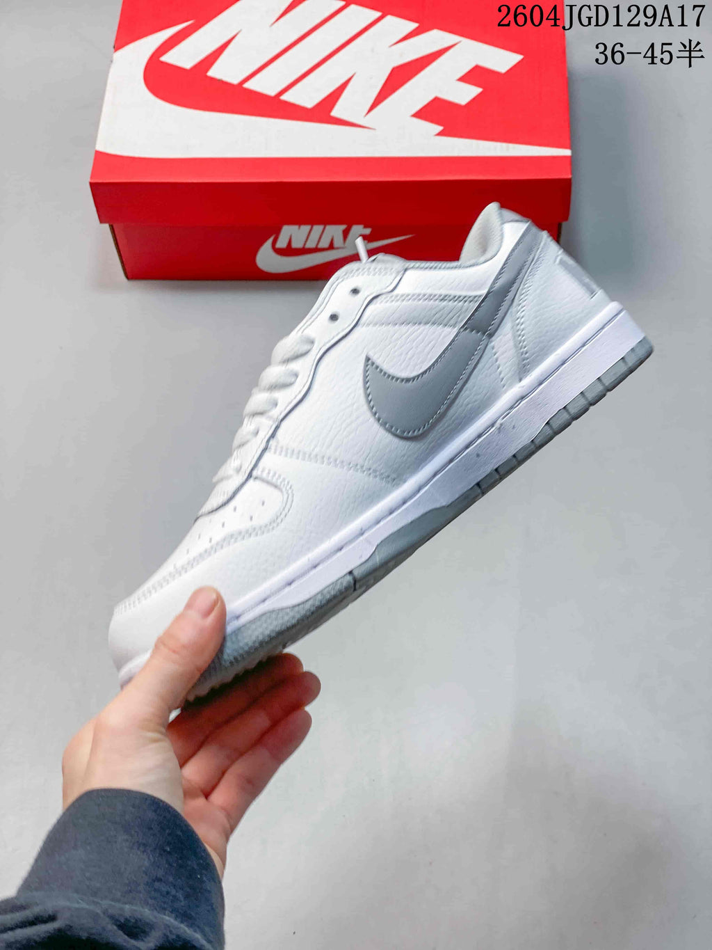 Side profile of a white low-top sneaker with a grey Swoosh