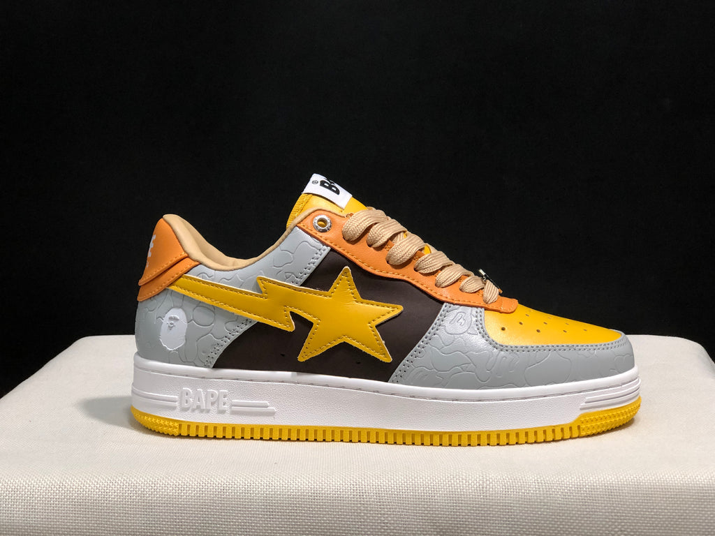 Single sneaker side view showing the BAPE branding on the white midsole and yellow outsole.