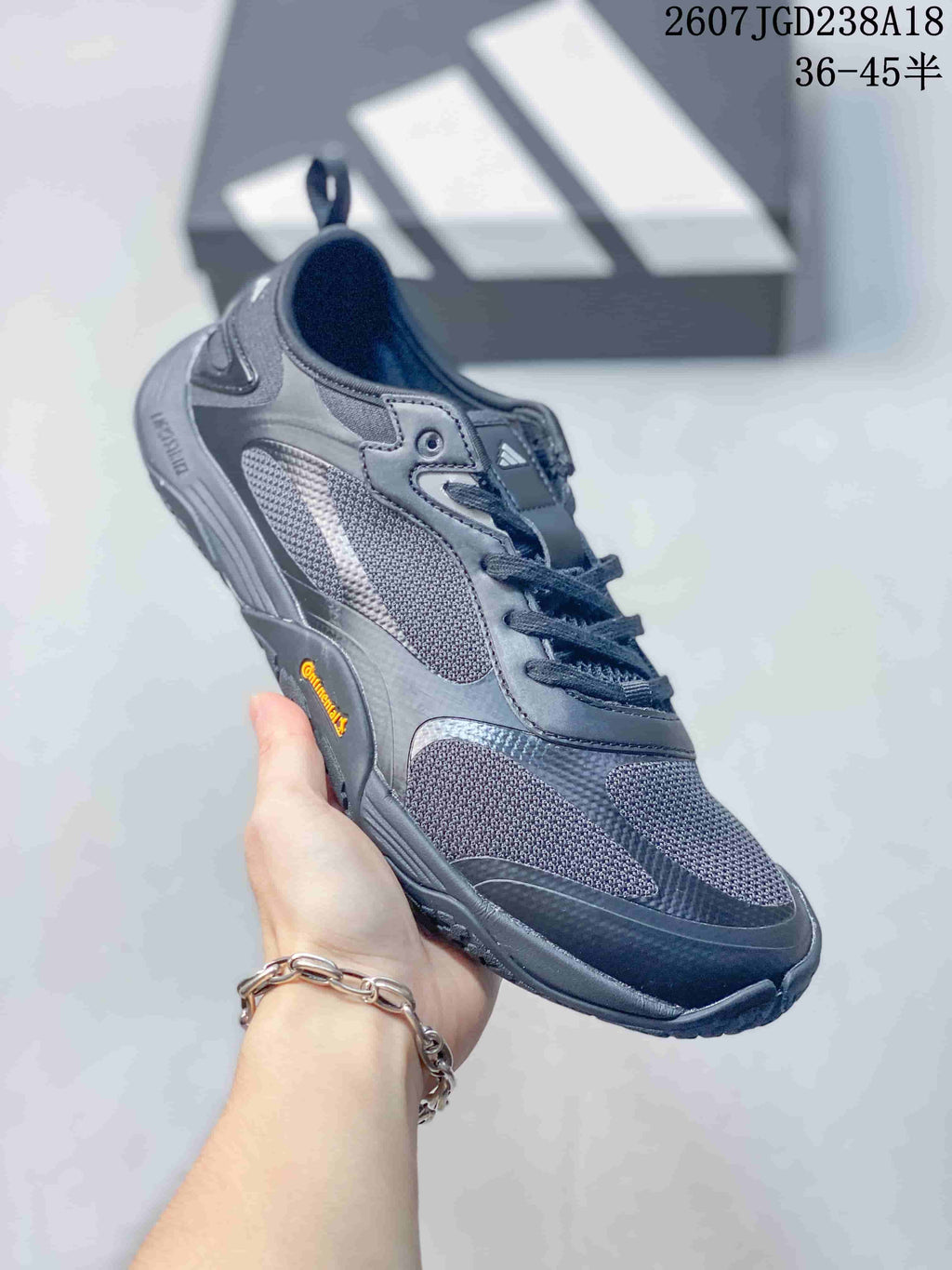 Angled side view of the dark gray sneaker showing the layered upper, lace system, pull tab, and outsole.
