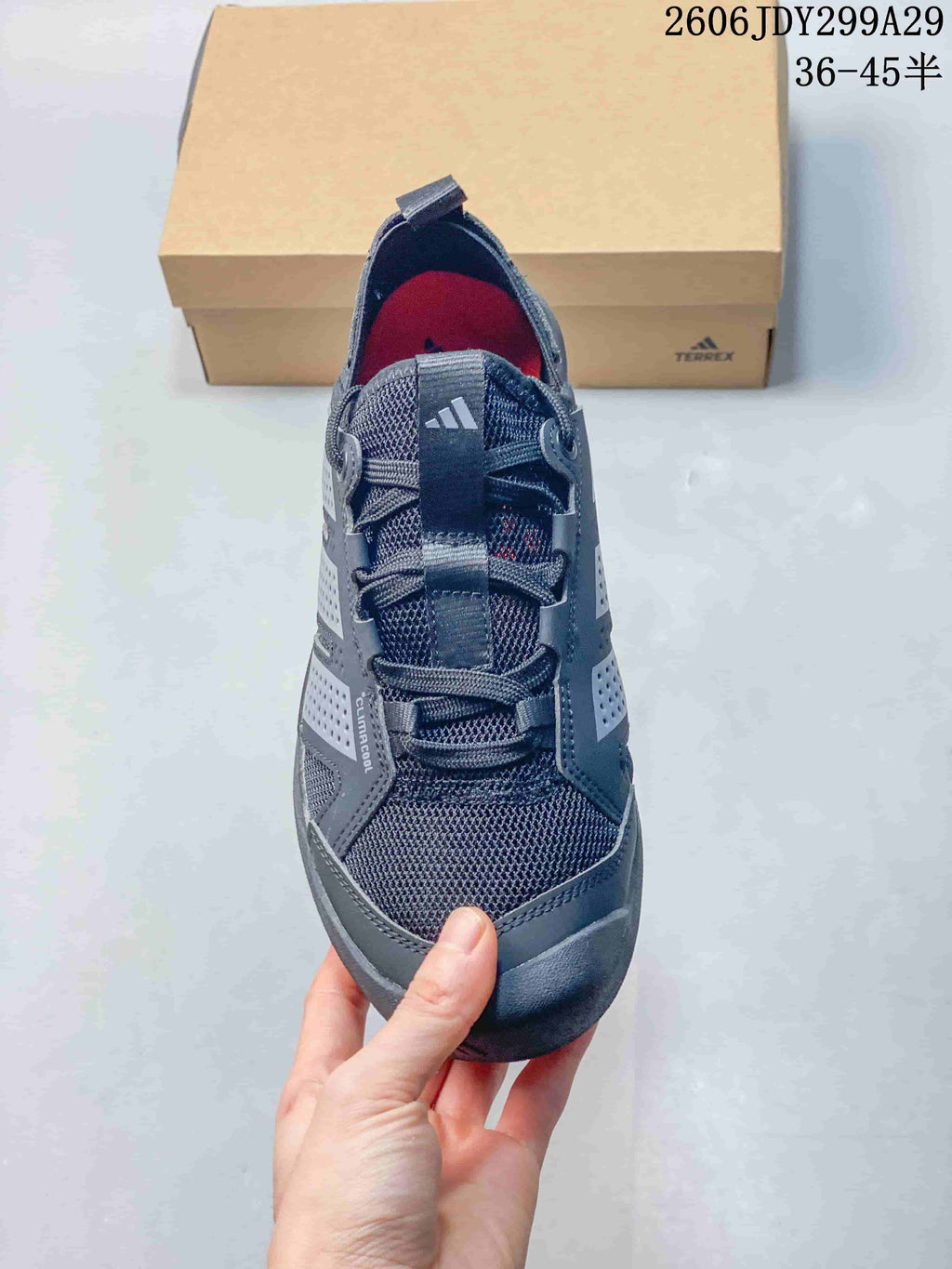 Top view of the sneaker showing the mesh toe box, laces, tongue pull tab, side overlays, and dark gray colorway.