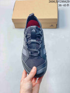 Top view of the sneaker showing the mesh toe box, laces, tongue pull tab, side overlays, and dark gray colorway.