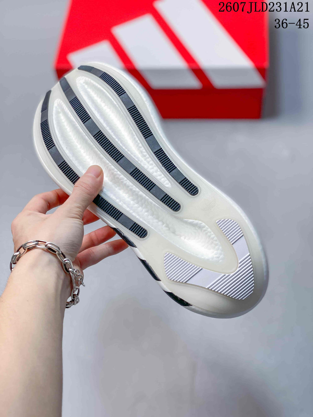 Underside view showing the white outsole with dark striped traction sections.