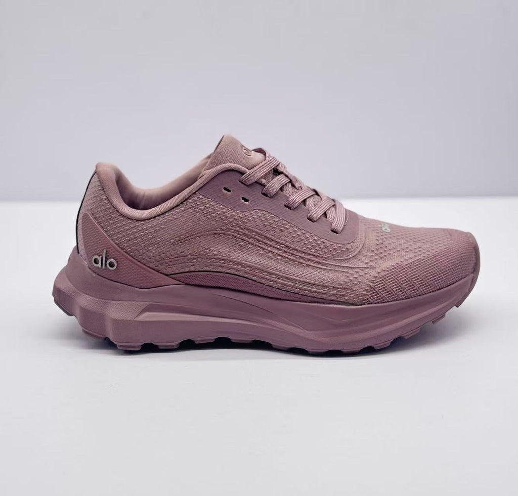 Side profile of a pink alo sneaker showing the lace-up upper, layered midsole, and side branding.
