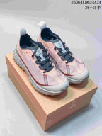 Pair of pink and gray Norda trail-style shoes on a box
