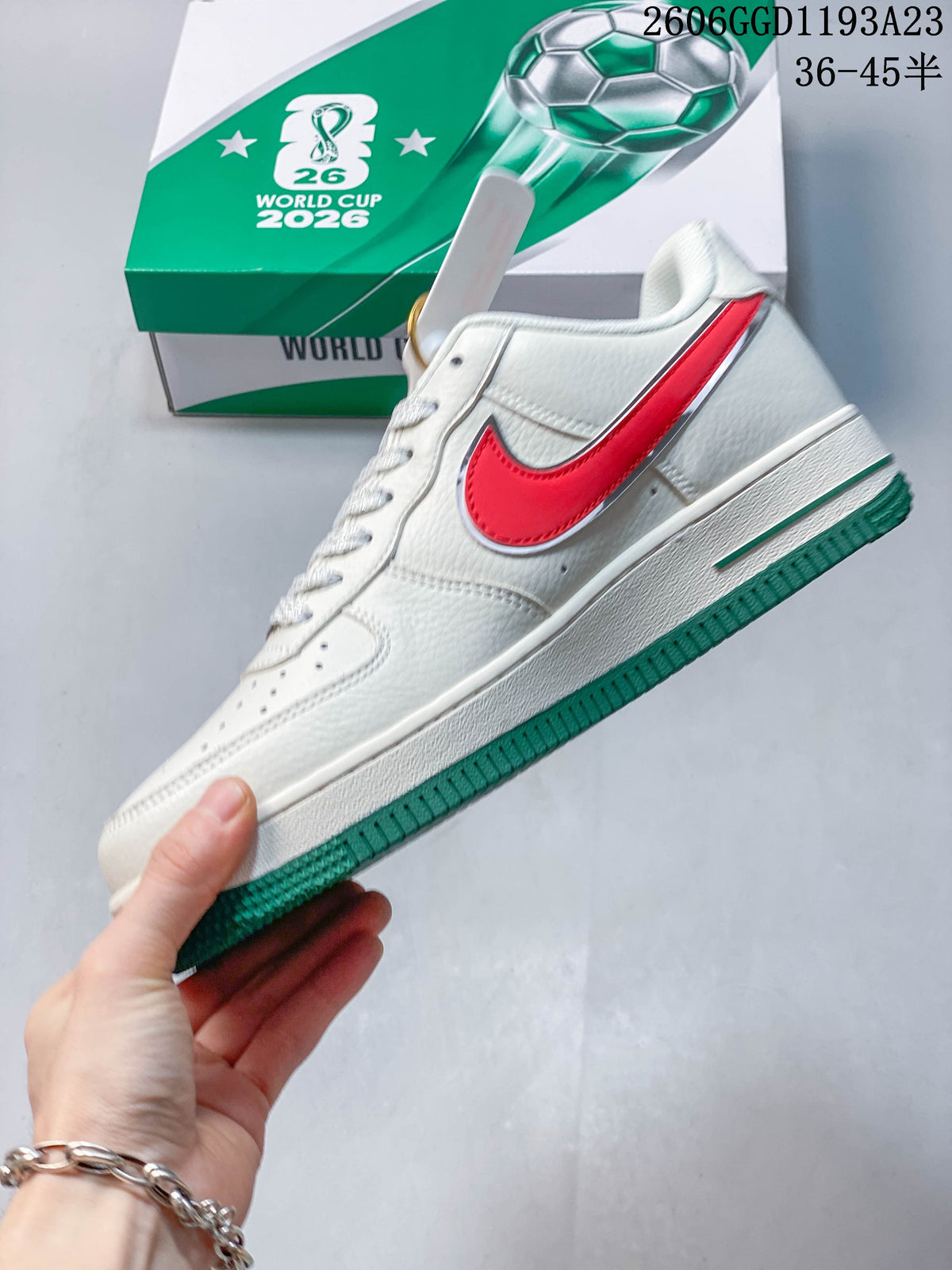 Side view of the white sneaker with red side accent and green outsole.