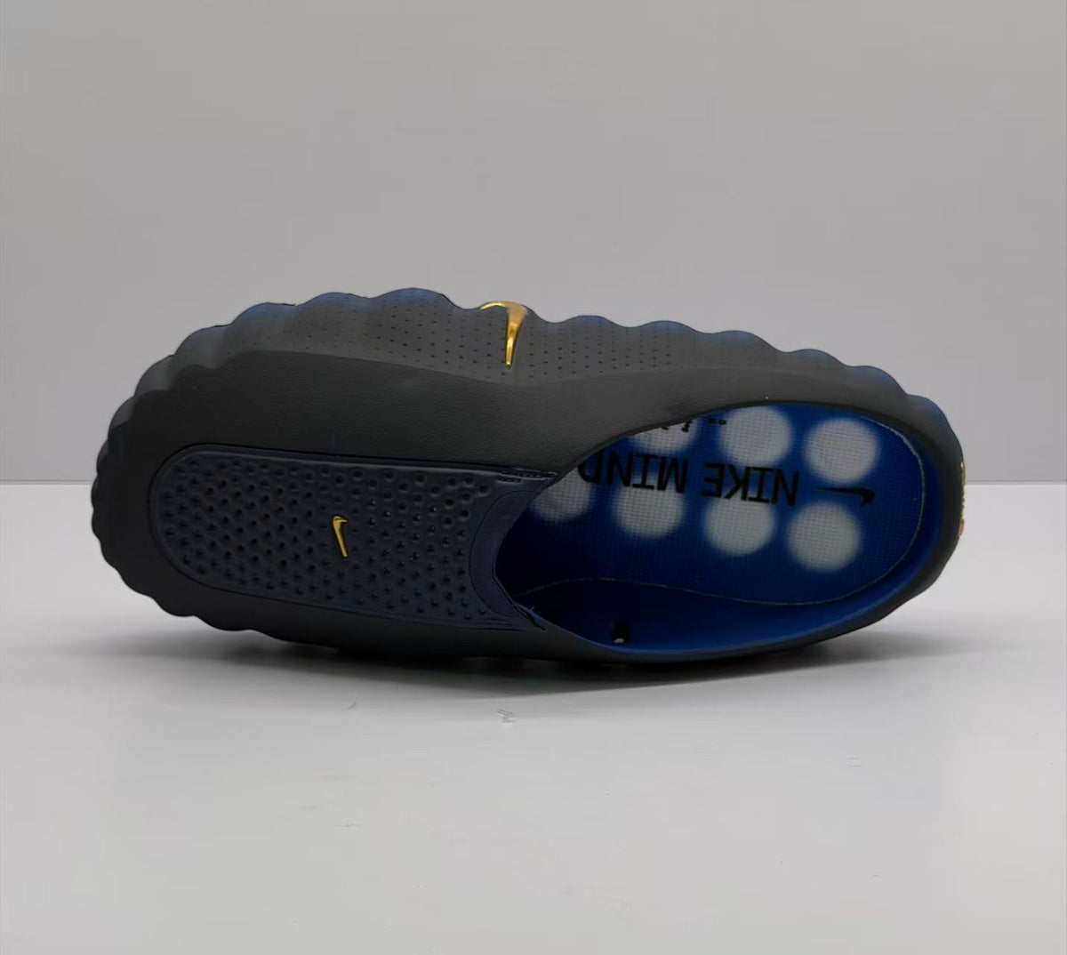 Top and outsole-side view showing the perforated upper and blue footbed.