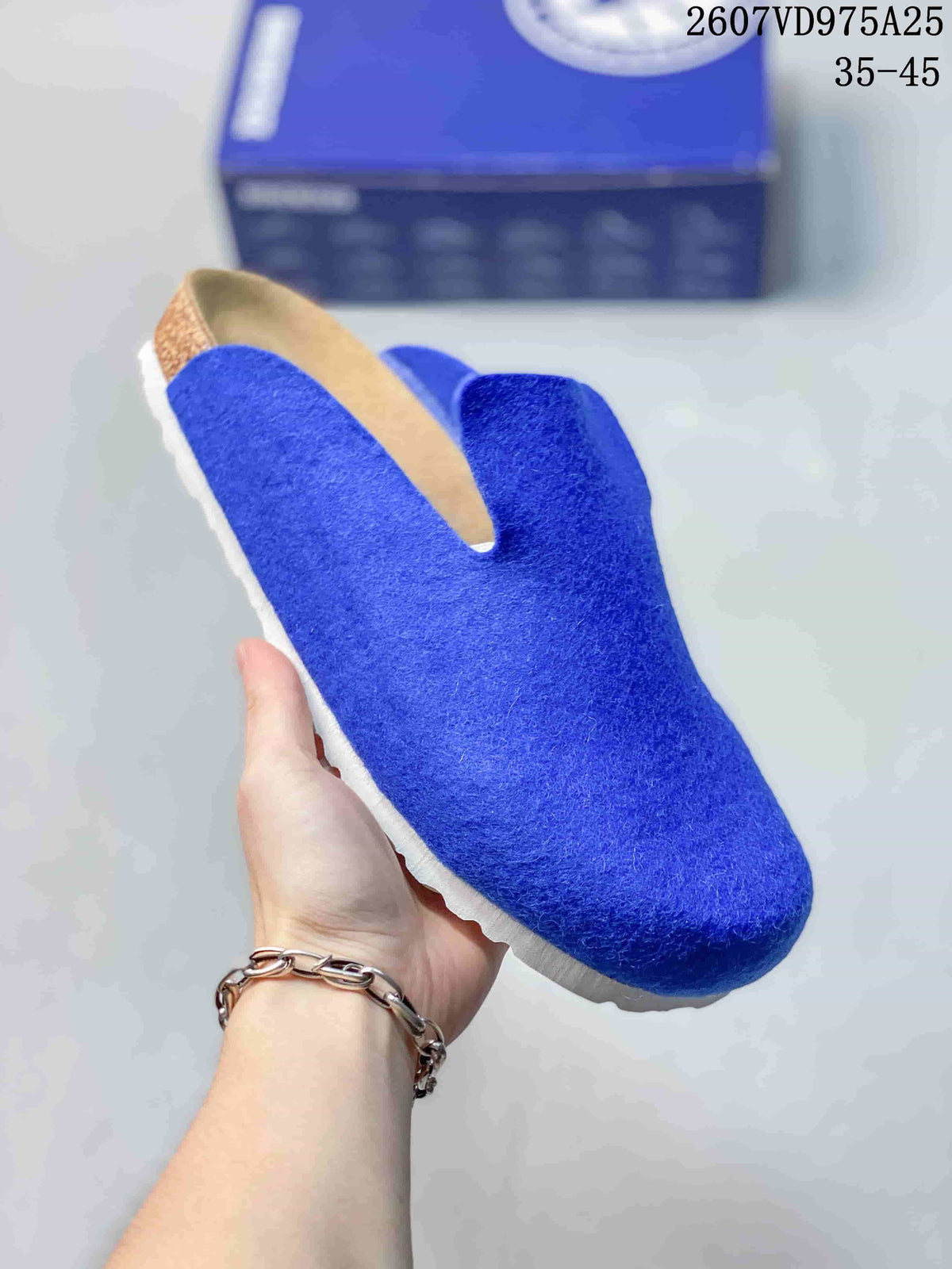 Close-up of a blue closed-toe slip-on clog showing its textured upper and light-colored sole.