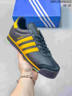 Dark Adidas Samoa sneaker with bright yellow side stripes and multicolor sole accents.