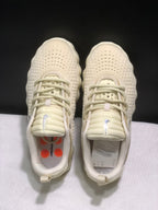Top-down view of the pair showing cream laces, padded tongues, textured uppers, and orange accents visible inside the shoes.