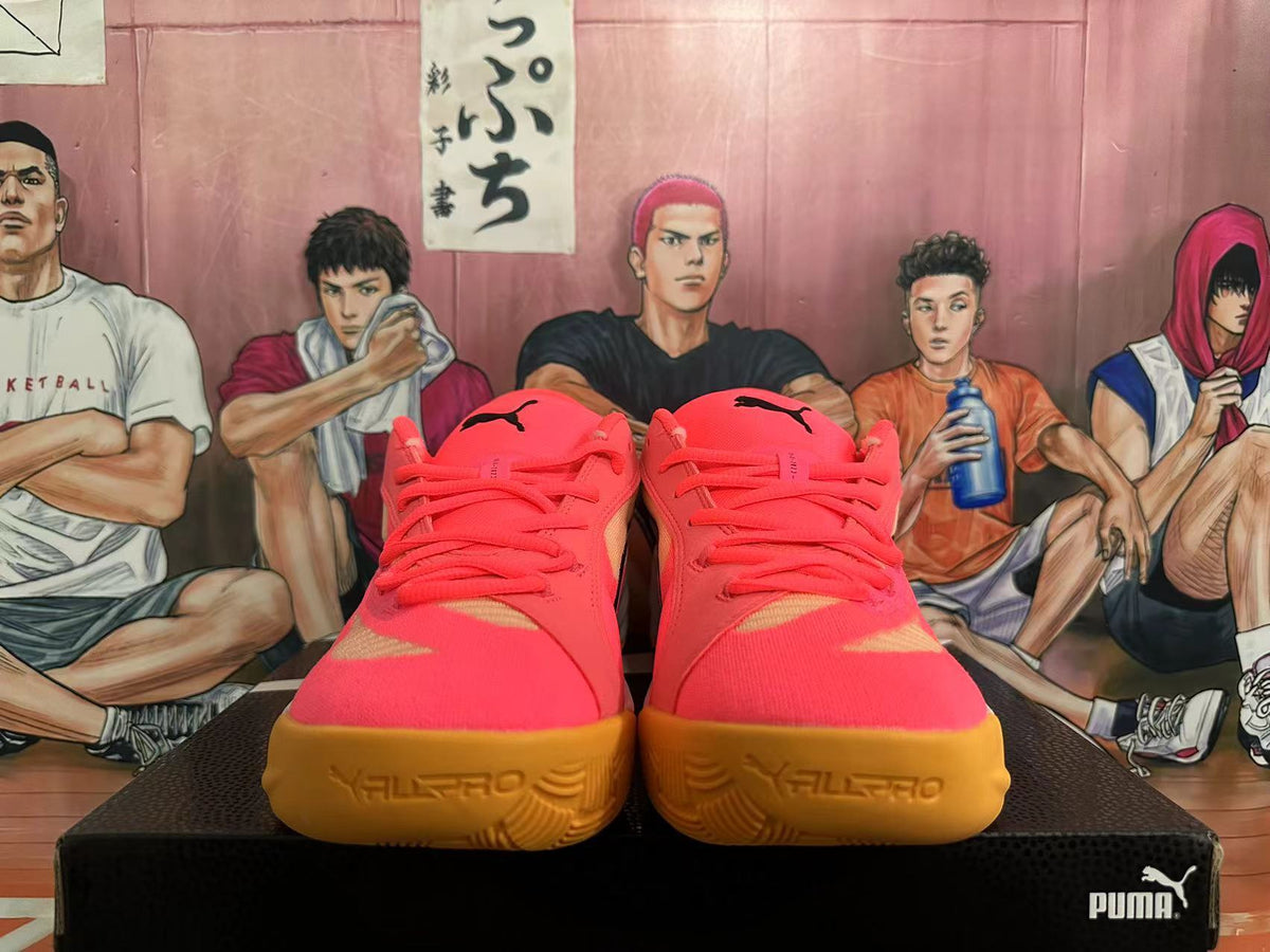 Front view of pink PUMA All-Pro basketball shoes with gold-colored outsoles.