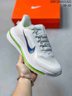 Angled side view highlighting the white upper, blue side branding, mesh panels, and green cushioning unit.
