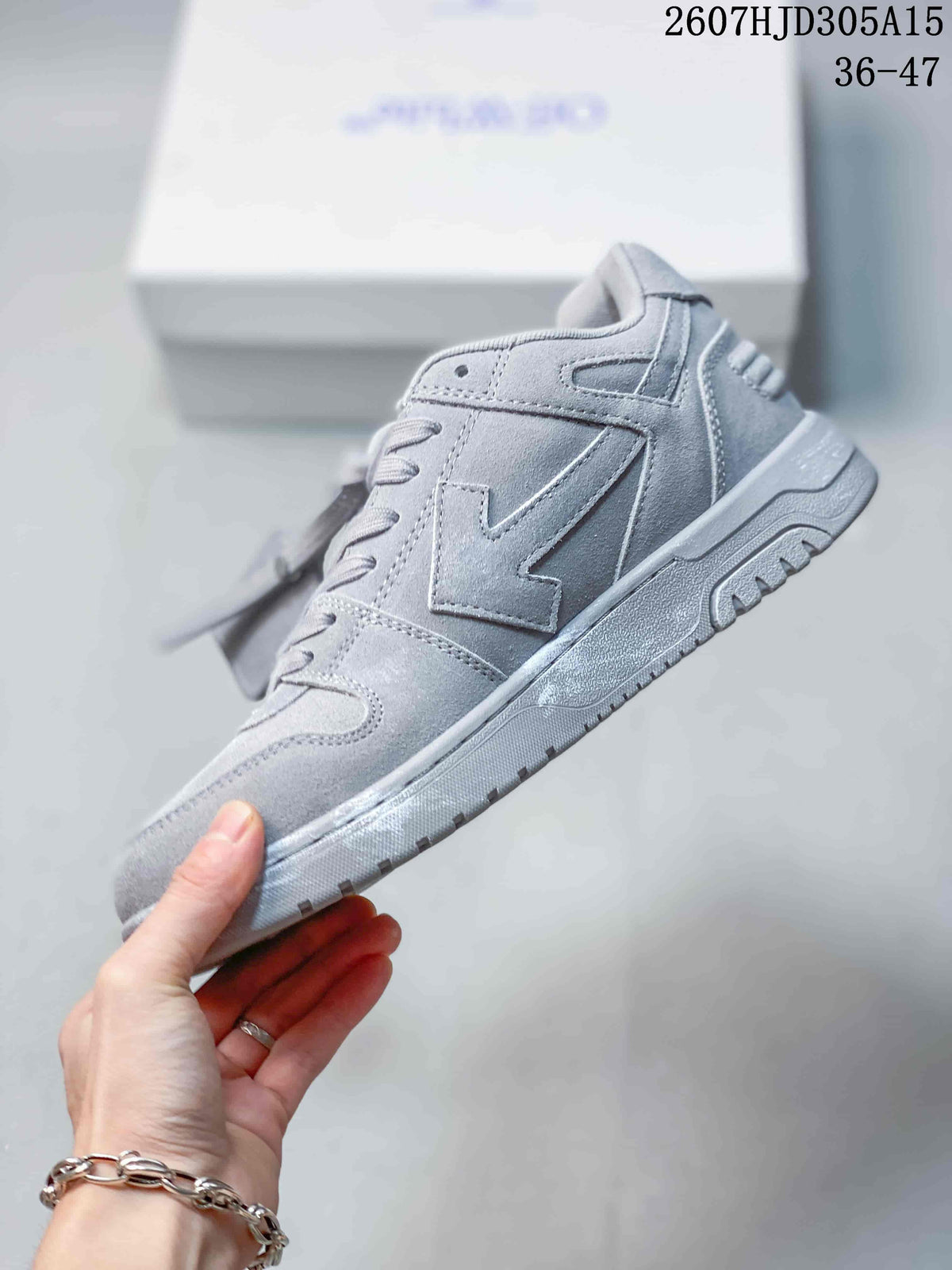 Side profile of the gray low-top sneaker showing layered panels, lace eyelets, and a textured outsole.