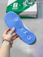 Blue outsole of the sneaker shown beside football-themed World Cup 2026 packaging.