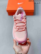 Top view showing the pink mesh-style upper, layered laces, padded tongue, and white toe branding.