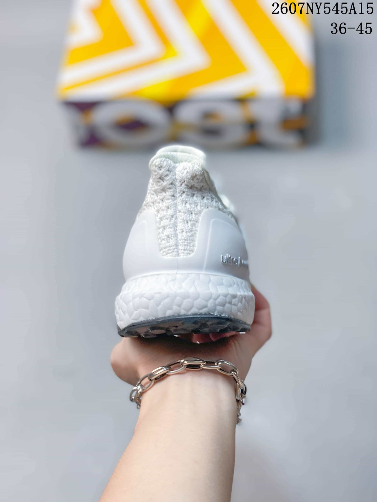 Rear view of a white Adidas Ultraboost Light sneaker showing the padded heel, knitted collar and textured midsole.