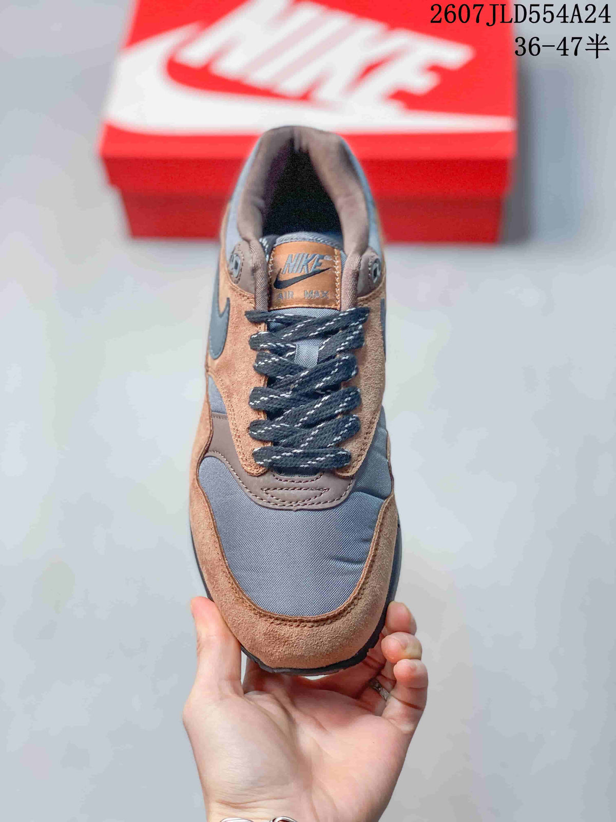 Top view of the Nike Air Max 1 sneaker showing the tongue branding, dark laces and layered toe box.