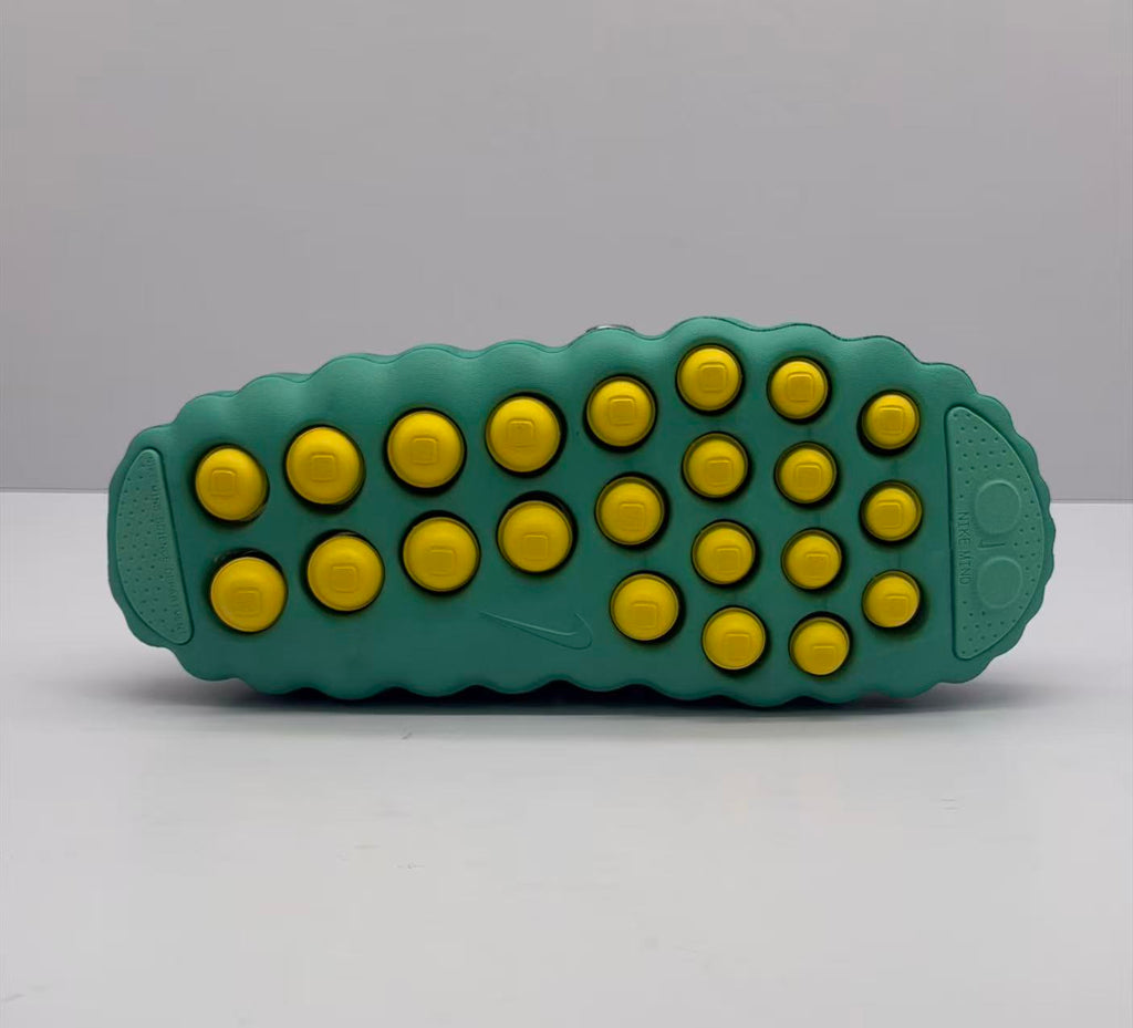 Bottom view showing the green outsole with multiple yellow circular pods and molded tread areas.
