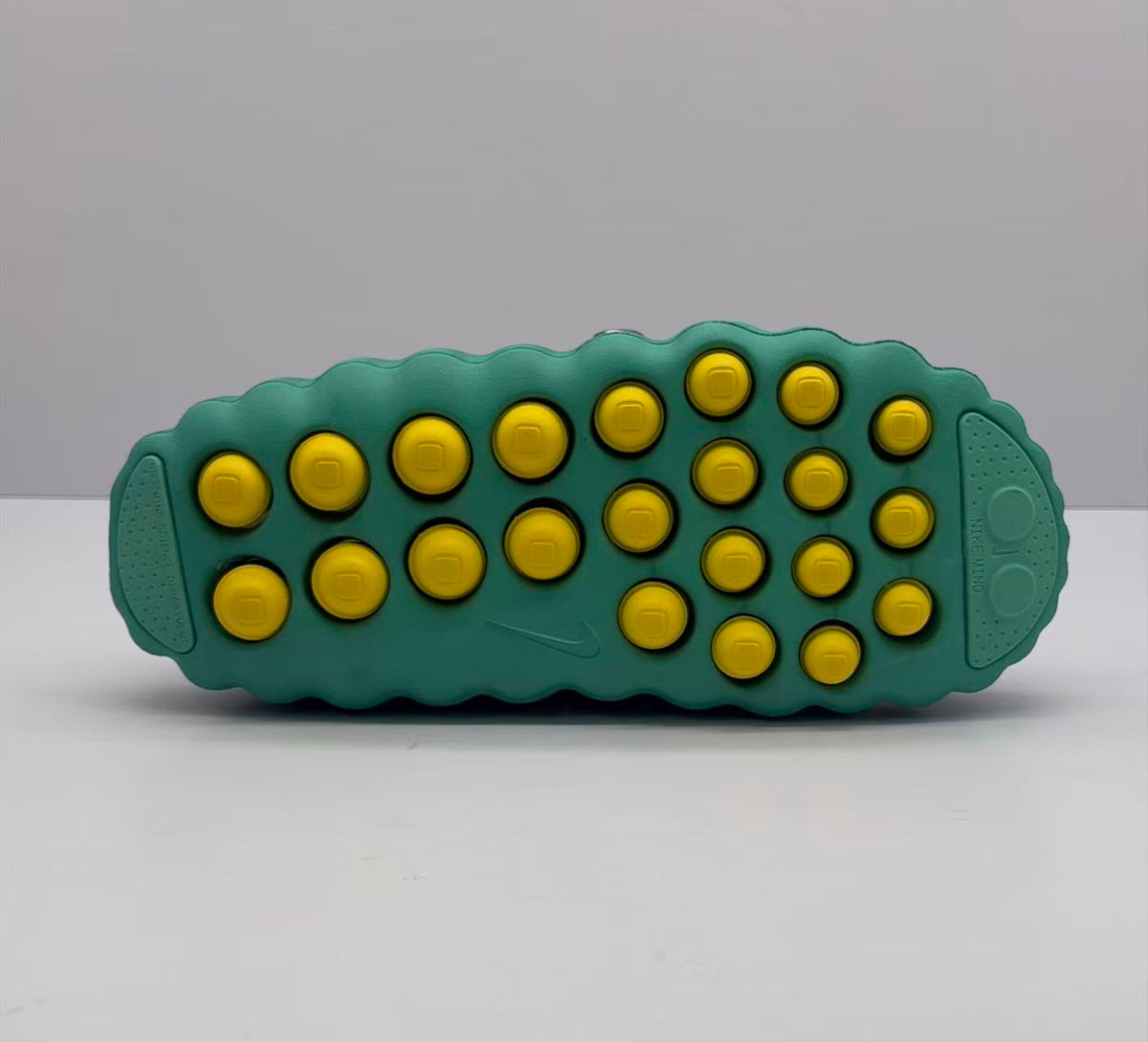 Bottom view showing the green outsole with multiple yellow circular pods and molded tread areas.