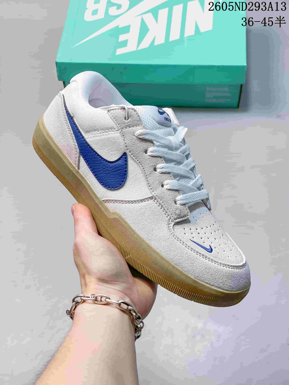 White and gray Nike SB Force 58 low-top shoe with blue Swoosh and gum-colored sole.