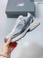 Side profile of the New Balance 509 sneaker showing the mesh-style upper, layered branding panels and chunky sole.