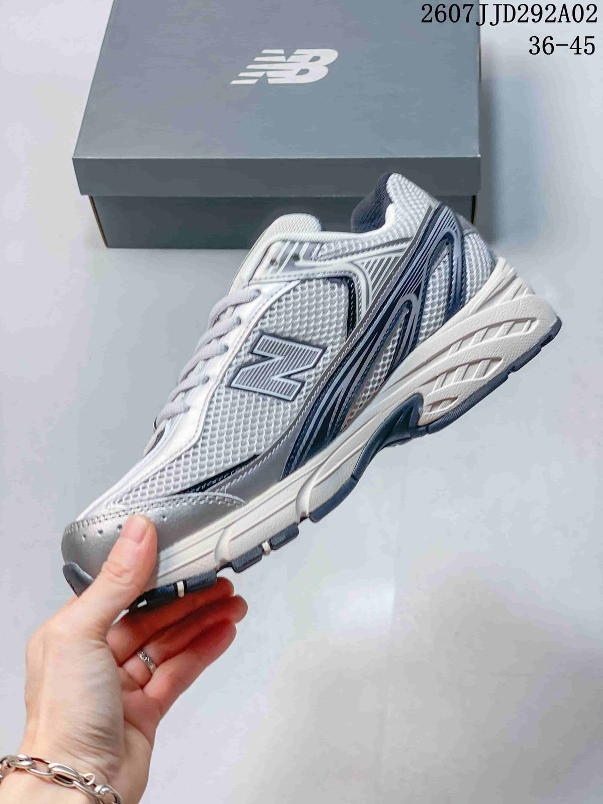 Side profile of the New Balance 509 sneaker showing the mesh-style upper, layered branding panels and chunky sole.