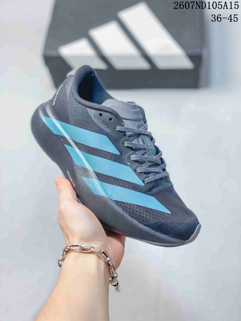 Angled side view of the sneaker showing the dark gray textile-look upper, bright blue stripes and low-profile shape.