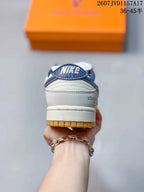 Rear view of a sneaker showing the navy heel detail, white upper, branding, and gum-colored outsole.