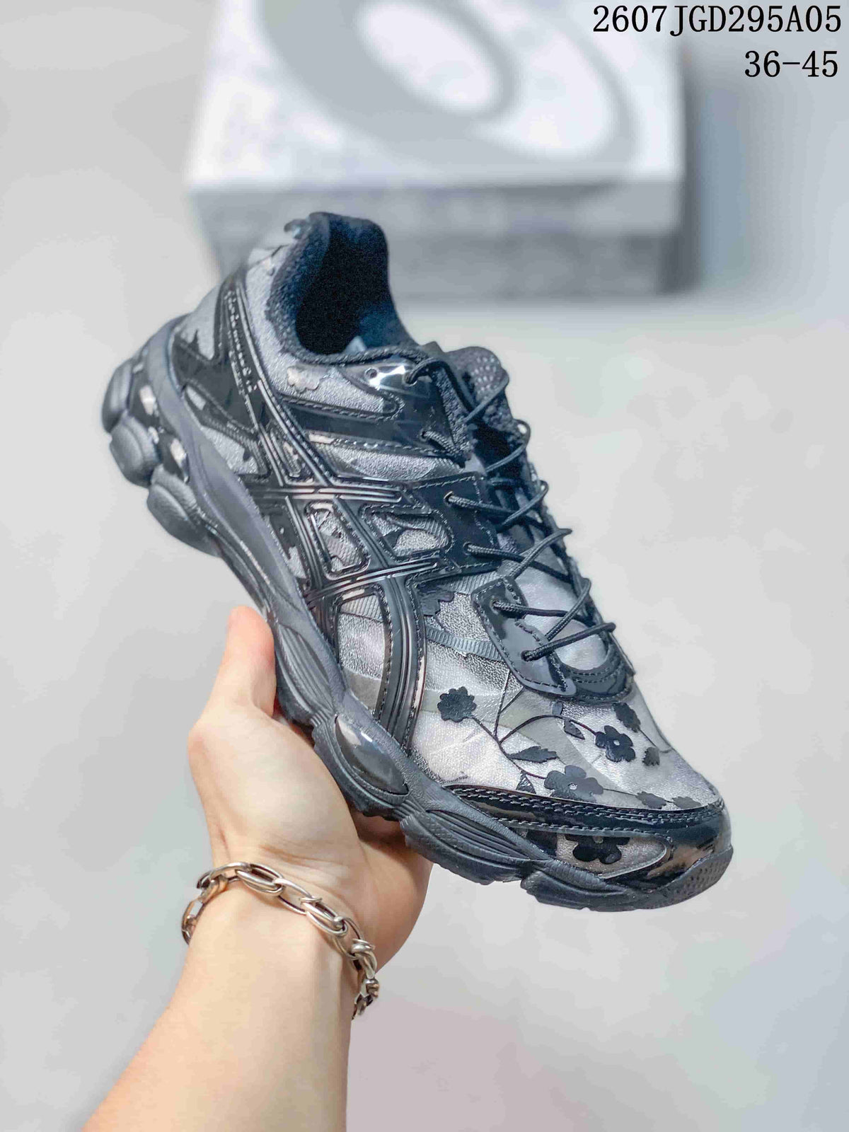 Angled side view showing the dark gray floral upper and layered sole.