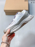 Side profile of the white and grey Nike sneaker showing layered overlays, a Swoosh logo, reinforced heel area and segmented outsole.
