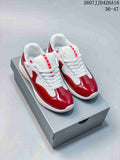 Pair of red and white Prada-branded platform sneakers displayed on a gray shoebox; style code 2607JJD426A16 and size range 36–47 are visible.