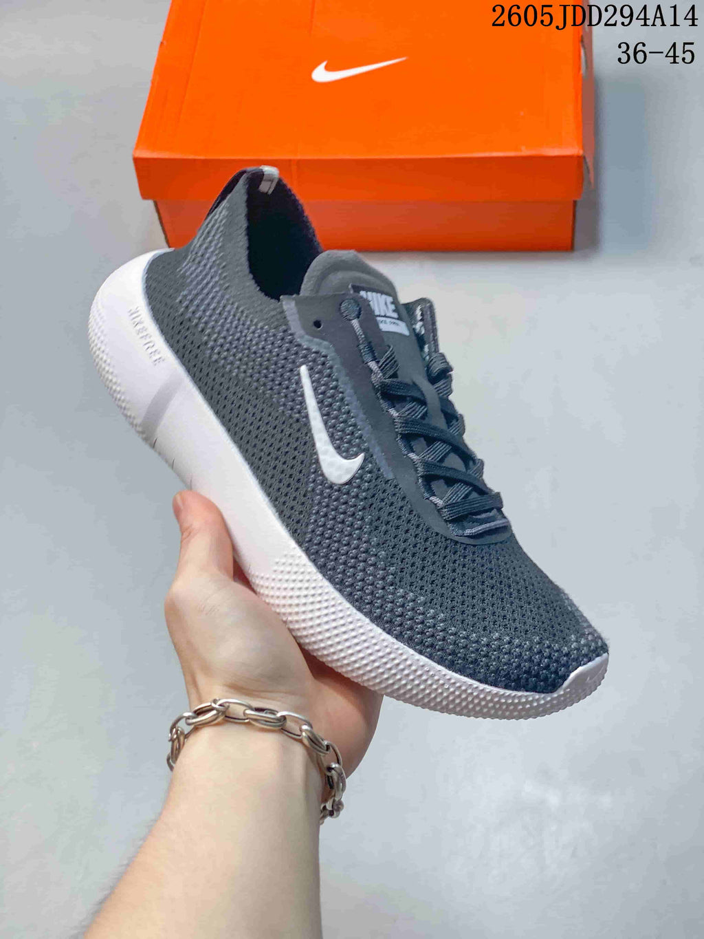 Angled side view of a dark gray Nike Free sneaker with a white Swoosh, white sole, and Nike Free branding on the heel area.