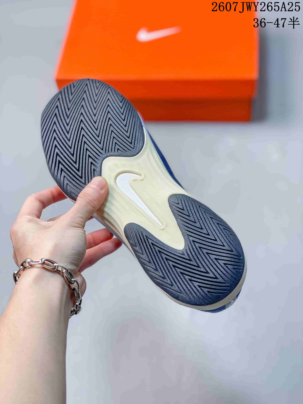 Underside view of a Nike Vapor 12 shoe showing the patterned rubber outsole and central white logo detail.
