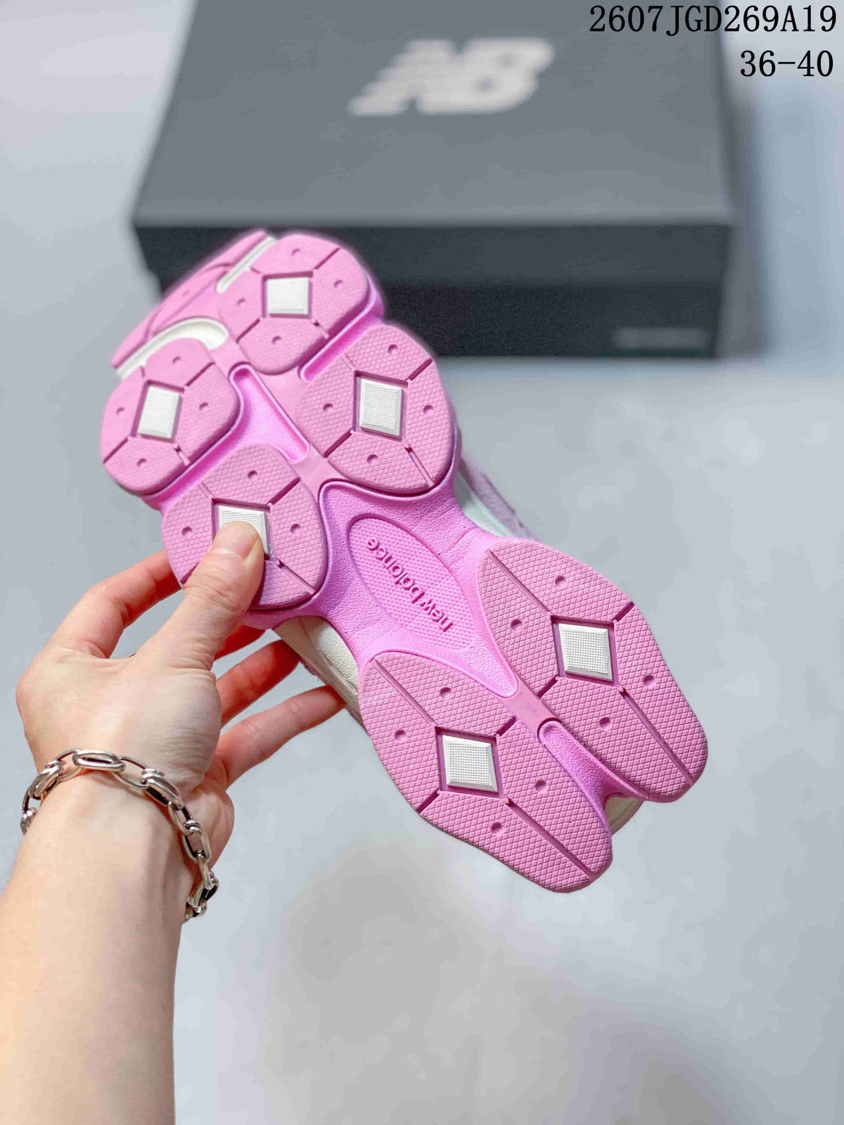Underside view of the pink outsole showing segmented traction areas and contrasting light-colored inserts.