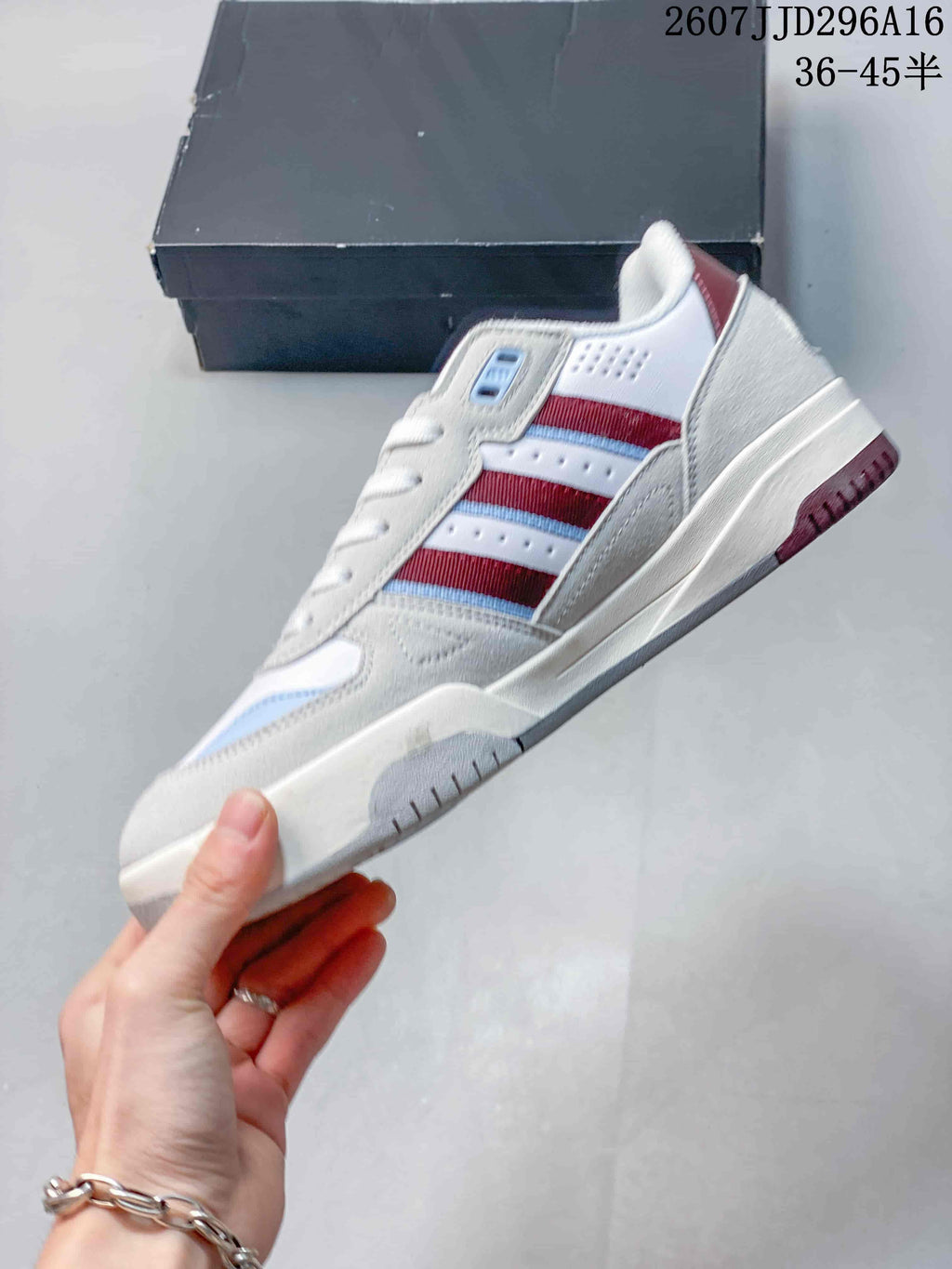 Side view of the white sneaker showing layered panels, red and blue side stripes, and a low-profile sole.
