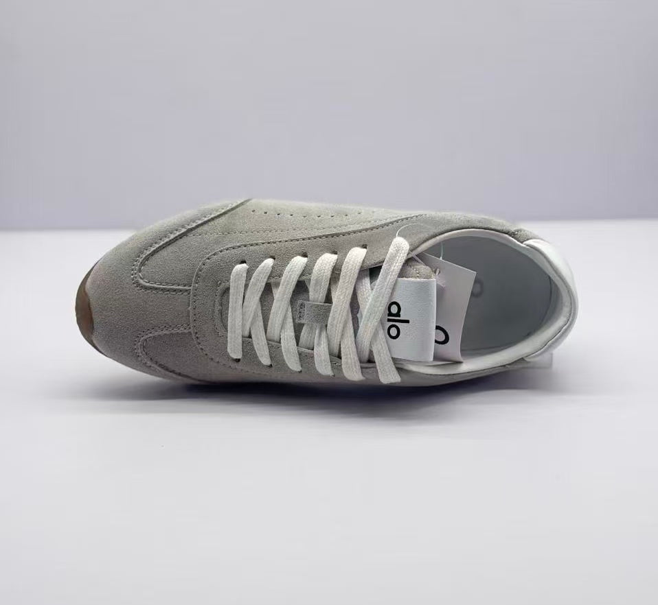 Top view of one gray lace-up sneaker showing the tongue, laces, perforated side panel, and toe shape.