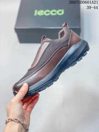 Side profile of the brown ECCO slip-on shoe showing textile panels, contrasting trim, and the raised lugged outsole.