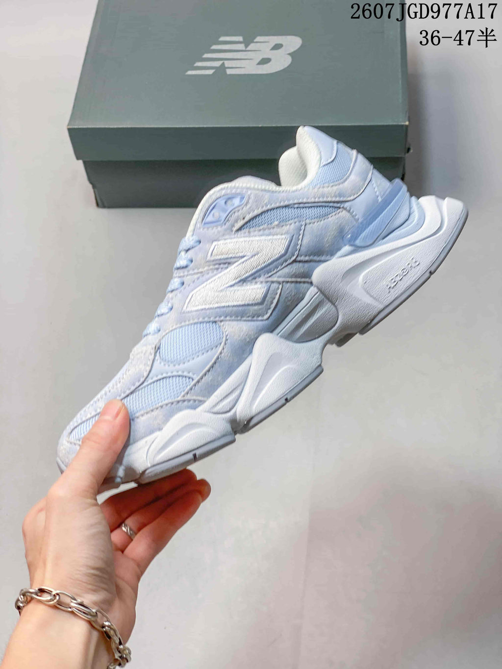 Side profile of the New Balance 9060 sneaker showing layered panels, mesh sections, and the sculpted raised midsole.