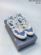 Pair of white and blue Onitsuka Tiger Serrano sneakers shown from above on a shoe box.