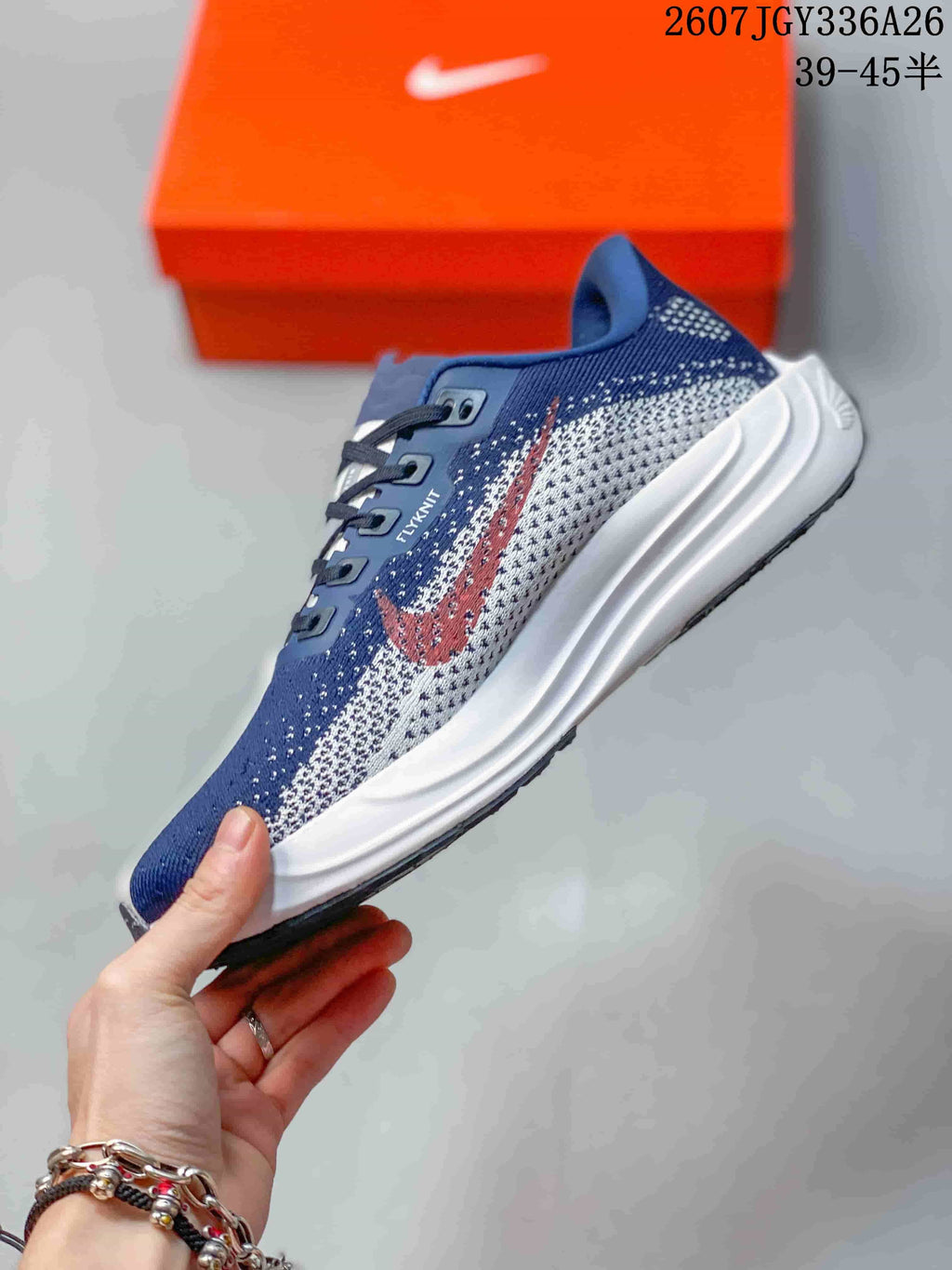 Side profile showing the navy and white patterned upper, red Swoosh detail, lace system and layered white midsole.