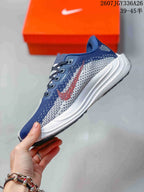 Side profile showing the navy and white patterned upper, red Swoosh detail, lace system and layered white midsole.