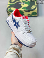 Angled side view of a white BAPE Sta sneaker with blue star detail, red collar lining and BAPE branding on the midsole.