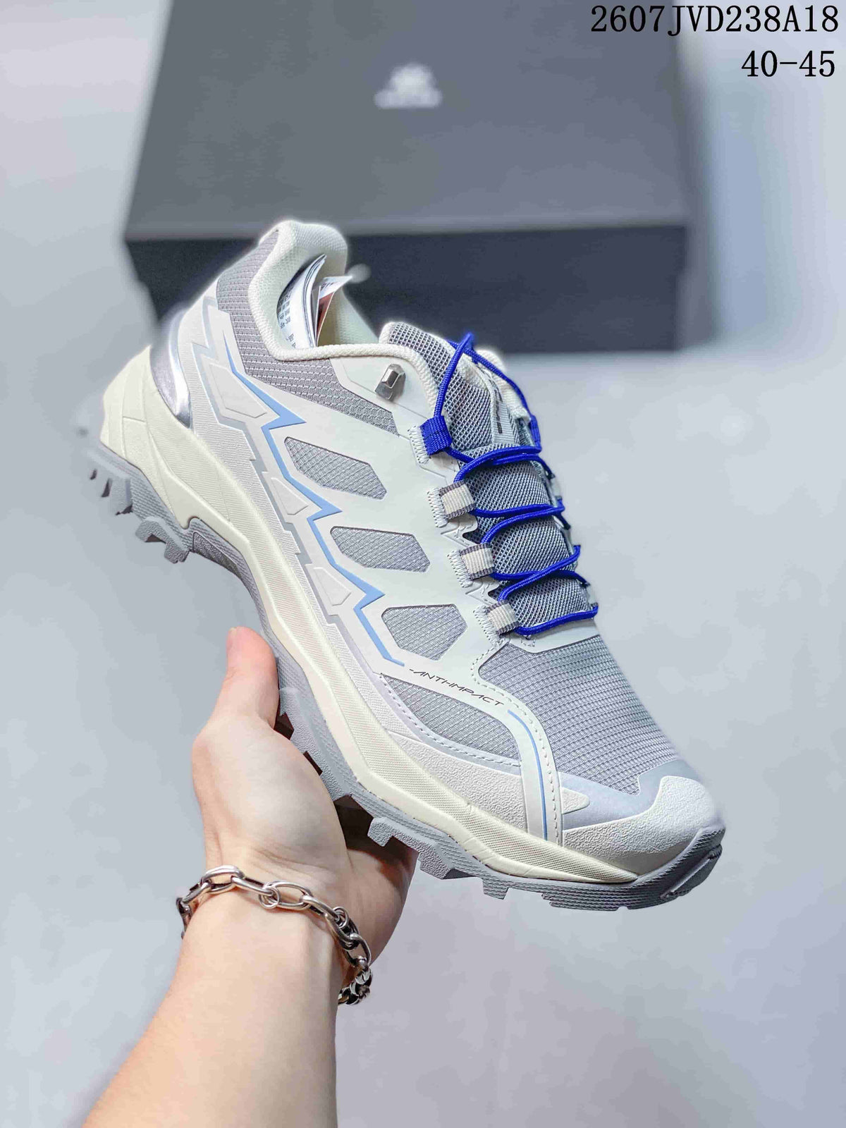 Close side view of the white and blue KAILAS hiking shoe, showing the textile panels, decorative overlays, padded collar, and lugged sole.