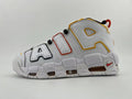 Side view of a white Nike Air More Uptempo sneaker with oversized AIR lettering and red, yellow, and black accents.