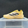 Side view of a yellow and black Adidas Adizero sneaker with white accents and a sculpted sole
