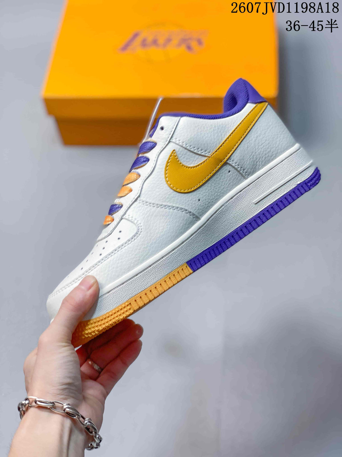 Side profile showing the white upper, gold Nike Swoosh, purple collar, and color-blocked outsole.